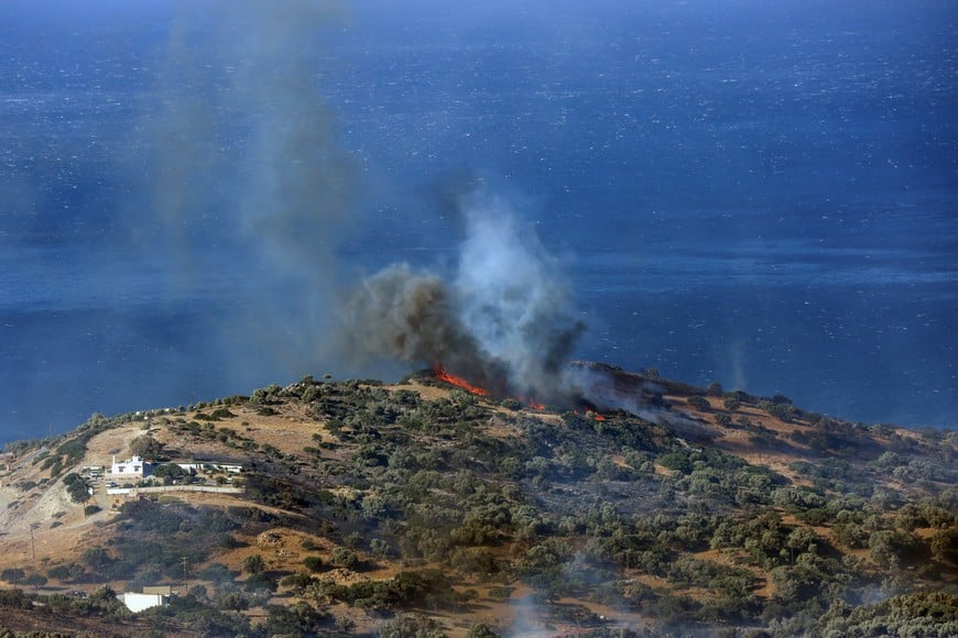Flames and smoke rise as a wildfire burns near the beach of Triopetra on the island of Crete, Greece, July 30, 2026. REUTERS/Stefanos Rapanis