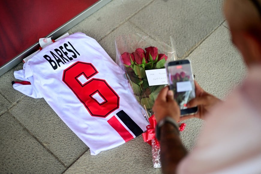 An AC Milan fan records a video of flowers and of a shirt with the name of former captain Franco Baresi at Casa Milan, following his death at the age of 66, in Milan, Italy, July 31, 2026. REUTERS/Daniele Mascolo TPX IMAGES OF THE DAY