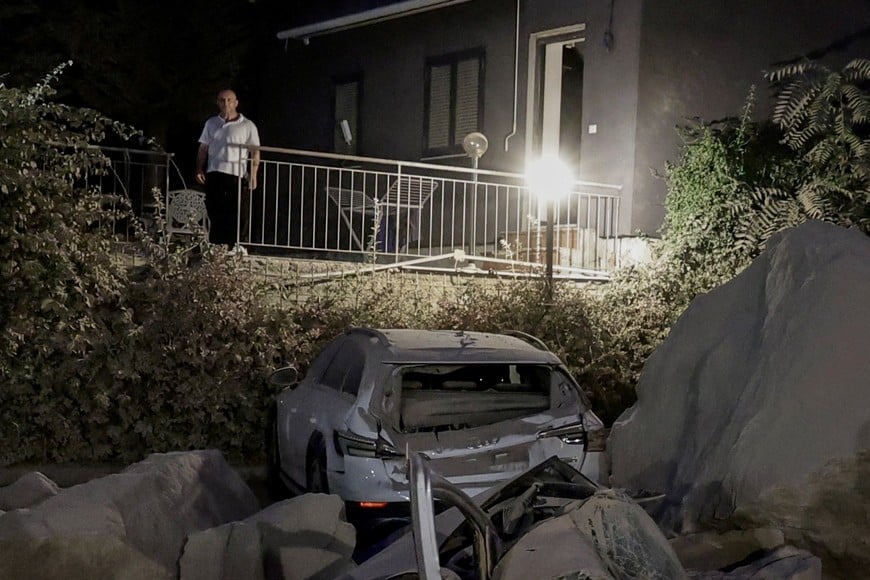 A man stands on a terrace above vehicles damaged by fallen boulders after a magnitude 4.7 earthquake struck the Campi Flegrei area, in Pozzuoli, near Naples, Italy, July 31, 2026. REUTERS/Salvatore Laporta