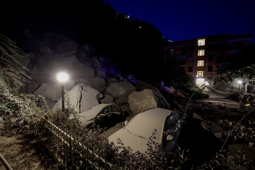 Dust-covered cars near boulders and debris below a residential building after a magnitude 4.7 earthquake struck the Campi Flegrei area, in Pozzuoli, near Naples, Italy, July 31, 2026. REUTERS/Salvatore Laporta