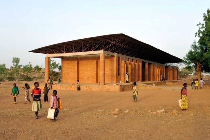 Francis Kéré. Escuela Primaria de Gando, Burkina Faso (2001). La innovación no siempre depende de la alta tecnología. Mediante materiales locales, participación comunitaria y estrategias bioclimáticas, la obra demuestra que la arquitectura contemporánea también puede surgir desde la tradición y el compromiso social.