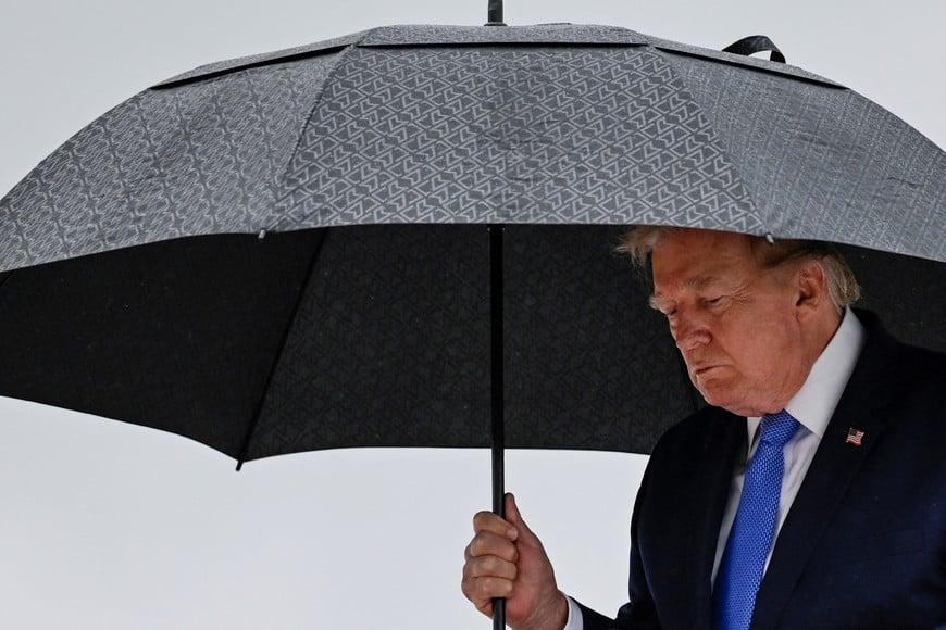 U.S. President Donald Trump holds an umbrella as he disembarks Air Force One at Joint Base Andrews, in Maryland, U.S., August 2, 2026. REUTERS/Daniel Heuer