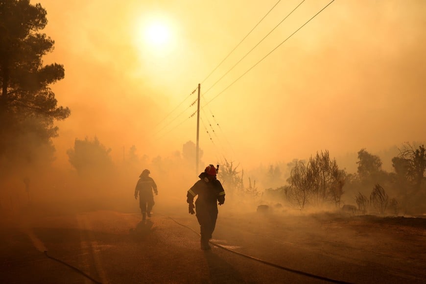 Firefighters battle a wildfire near the Agia Paraskevi village, Greece, August 2, 2026. REUTERS/Stelios Misinas