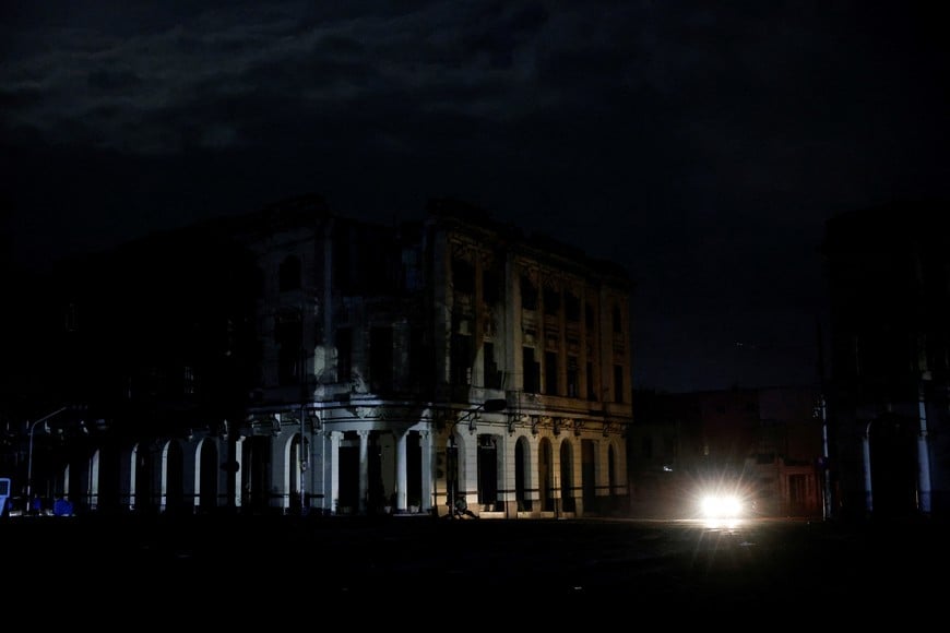 A car illuminates the facade of a building as Cuba's electricity grid collapsed late on Sunday, plunging the island of about 10 million people into darkness as blackouts become more frequent, in Havana, Cuba August 3, 2026. REUTERS/Norlys Perez