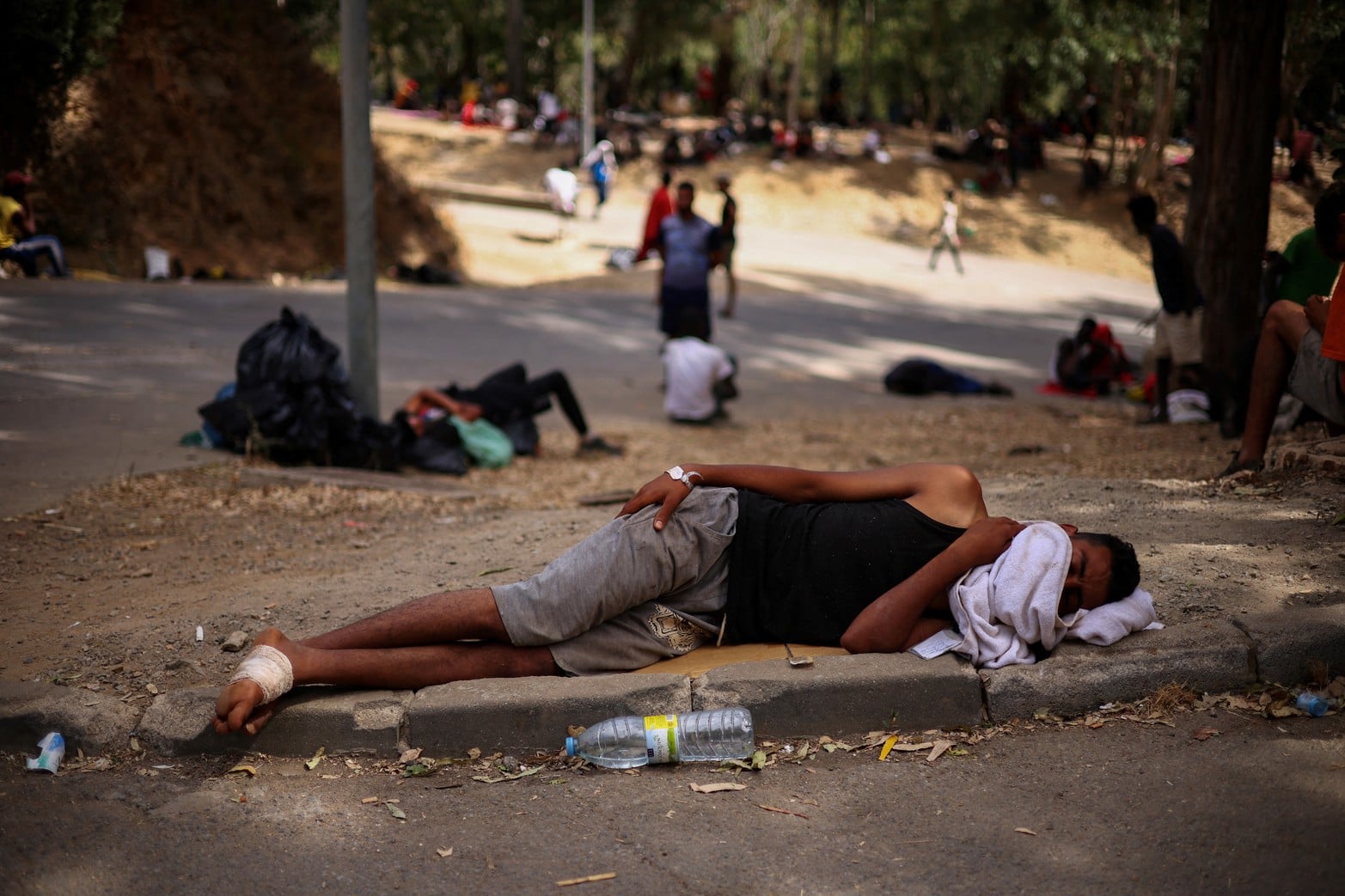 Migrantes esperan a las afueras del centro de acogida temporal de Ceuta (CETI), que actualmente se encuentra a plena capacidad.