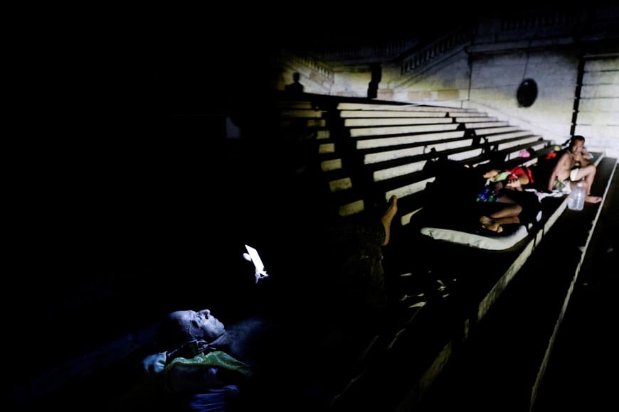People sleep and rest outdoors on the steps of the University of Havana to escape the heat after Cuba's electricity grid collapsed late on Sunday, plunging the island of about 10 million people into darkness as blackouts become more frequent, in Havana, Cuba August 3, 2026. REUTERS/Norlys Perez TPX IMAGES OF THE DAY