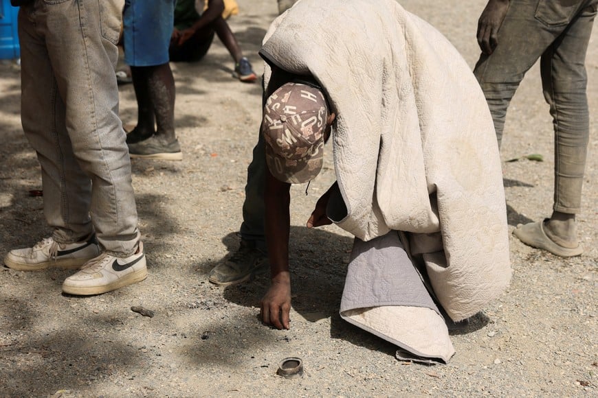 A migrant looks for crumbs on a beach in Ceuta, following mass crossings of migrants on foot and by sea from Morocco into Spanish territory, in Ceuta, Spain, August 3, 2026. REUTERS/Violeta Santos Moura
