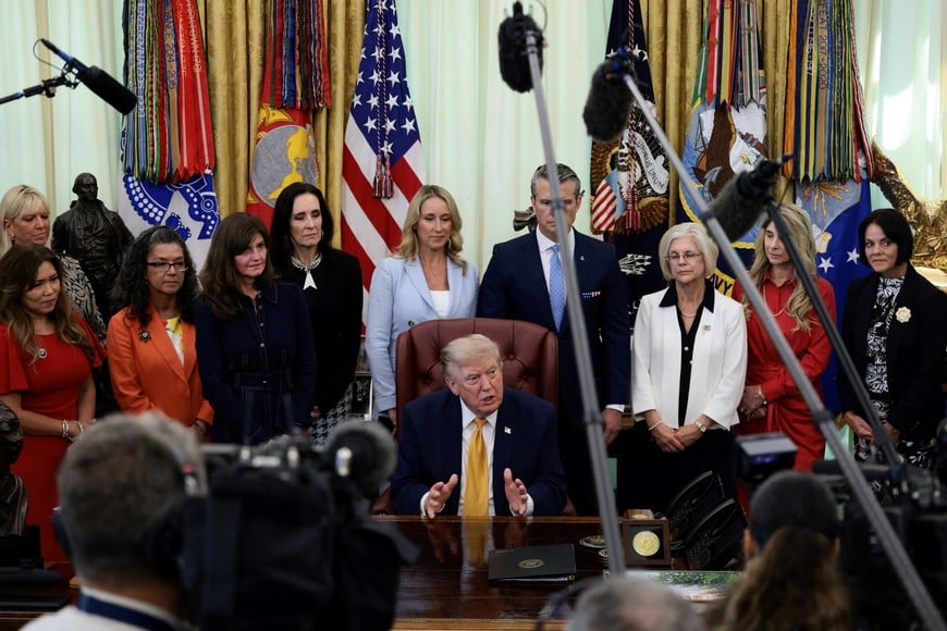 U.S. President Donald Trump answers questions from the media after signing an executive order establishing the President's Military Spouse Commission to be chaired by Jennifer Rauchet, wife of Secretary of Defense Pete Hegseth, in the Oval Office at the White House in Washington, D.C., U.S., August 3, 2026. REUTERS/Evelyn Hockstein