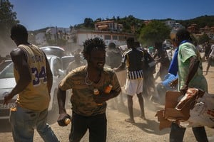 Migrantes, no originarios de Marruecos, reciben jugos en una playa de Ceuta, tras las travesías masivas a pie y por mar desde Marruecos. REUTERS/Pedro Nunes