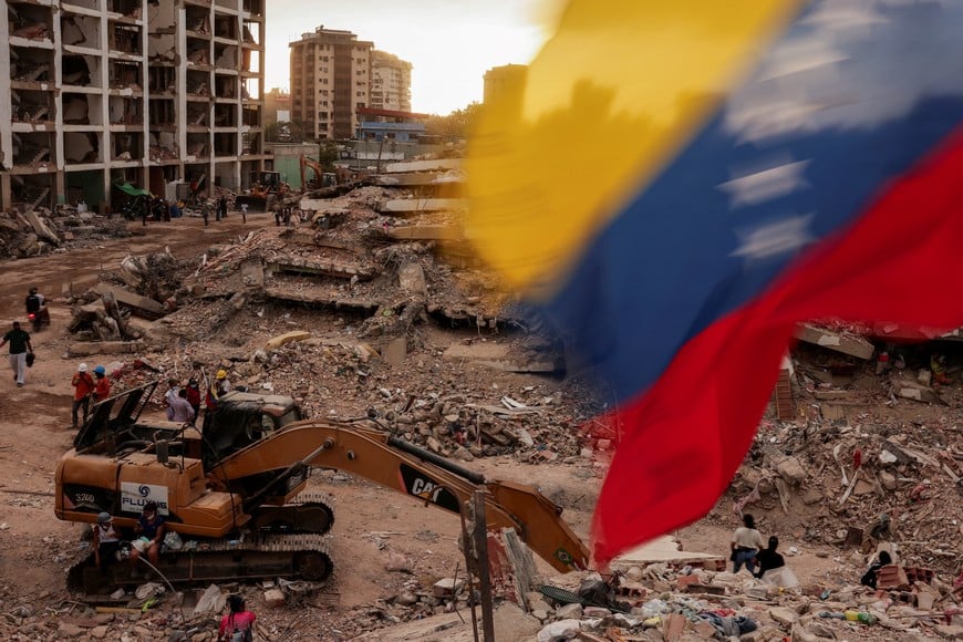 A Venezuelan flag waves as people search for the bodies of their loved ones beneath the rubble, after earthquakes rocked Venezuela on June 24, killing and displacing thousands of people, in Caraballeda, La Guaira, Venezuela, July 29, 2026. REUTERS/Gaby Oraa