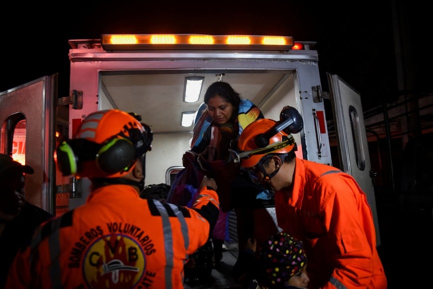 Volunteer firefighters help an evacuated resident after increased activity at Guatemala's Fuego volcano, which prompted authorities to raise the alert level to orange, in San Juan Alotenango, Guatemala, August 4, 2026. REUTERS/Cristina Chiquin
