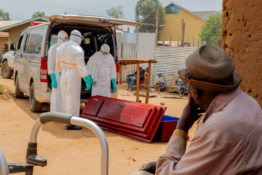 Members of the Civil Protection, a local community-based team that works to help mitigate the spread of the Ebola virus and ensure burials happen safely and quickly, wearing personal protective equipment (PPE), handle a wooden coffin before loading the body of an unidentified man, who according to his family, died of Ebola, as they attend to retrieve it from his house, as aid agencies intensify efforts to contain a new Ebola outbreak involving the Bundibugyo strain, in Bunia, Ituri province, Democratic Republic of Congo, July 10, 2026. REUTERS/Gradel Muyisa Mumbere TPX IMAGES OF THE DAY