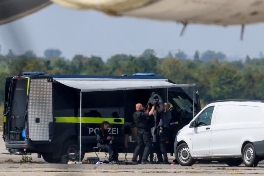 Police officers work in the vicinity of an Antonov cargo plane, near which a drone was found, at Leipzig/Halle Airport in Schkeuditz, Germany, August 5, 2026, after the police said explosives experts examined a drone near a runway, and after a DHL cargo aircraft hit an unknown object as it was climbing away from the airport overnight, prompting an unscheduled landing in Hanover, according to a source familiar with the incident. REUTERS/Axel Schmidt     TPX IMAGES OF THE DAY