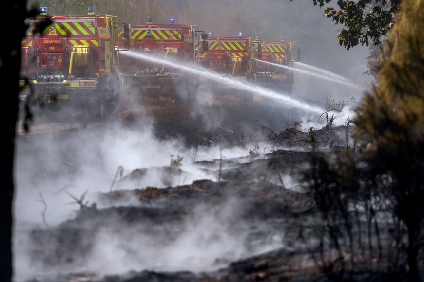 Firefighters work to battle wildfires amid drought conditions following a heatwave and water shortages across much of France, in Marcheprime, Gironde department, France, July 27, 2026. REUTERS/Florion Goga     TPX IMAGES OF THE DAY