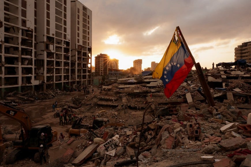 A Venezuelan flag waves as people search for the bodies of their loved ones beneath the rubble, after earthquakes rocked Venezuela on June 24, killing and displacing thousands of people, in Caraballeda, La Guaira, Venezuela, July 29, 2026. REUTERS/Gaby Oraa