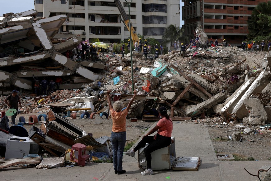 A woman prays as people work together to search for their loved ones amid debris in the aftermath of the June 24 earthquakes in Tanaguarena, La Guaira, Venezuela, July 20, 2026. REUTERS/Gaby Oraa     TPX IMAGES OF THE DAY