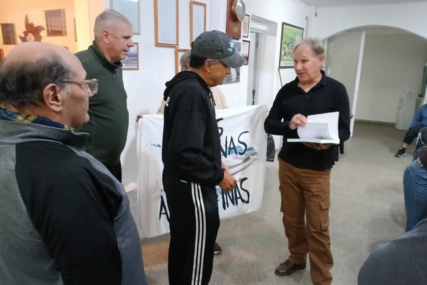 La entrega de uno de los ex combatientes a Enrique Cruz del libro que testimonia las experiencias de los santafesinos que lucharon en la guerra de 1982