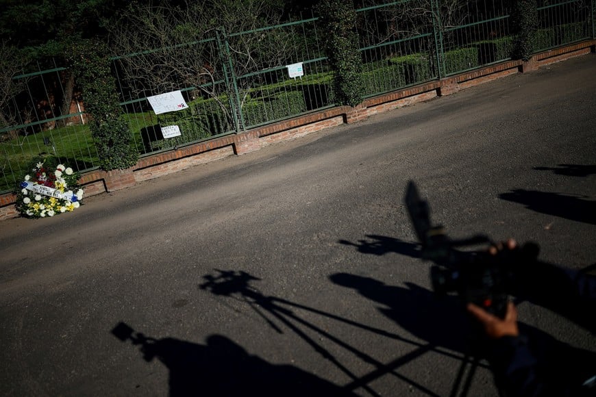 Members of the media work next to placards and a wreath outside El Prado Cemetery, following the death of Jorge Messi, the father of the footballer Lionel Messi, in Perez, Rosario department, Argentina, August 9, 2026. REUTERS/Agustin Marcarian