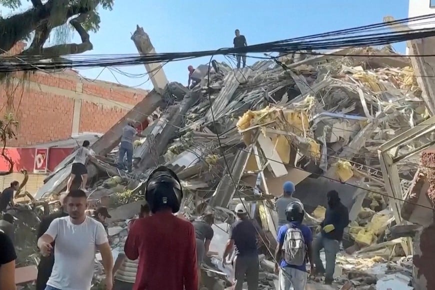 Rescue workers and residents stand around a collapsed building in the aftermath of an earthquake in Cali, Colombia, August 10, 2026 in this screengrab taken from a video. REUTERS/Reuters TV
