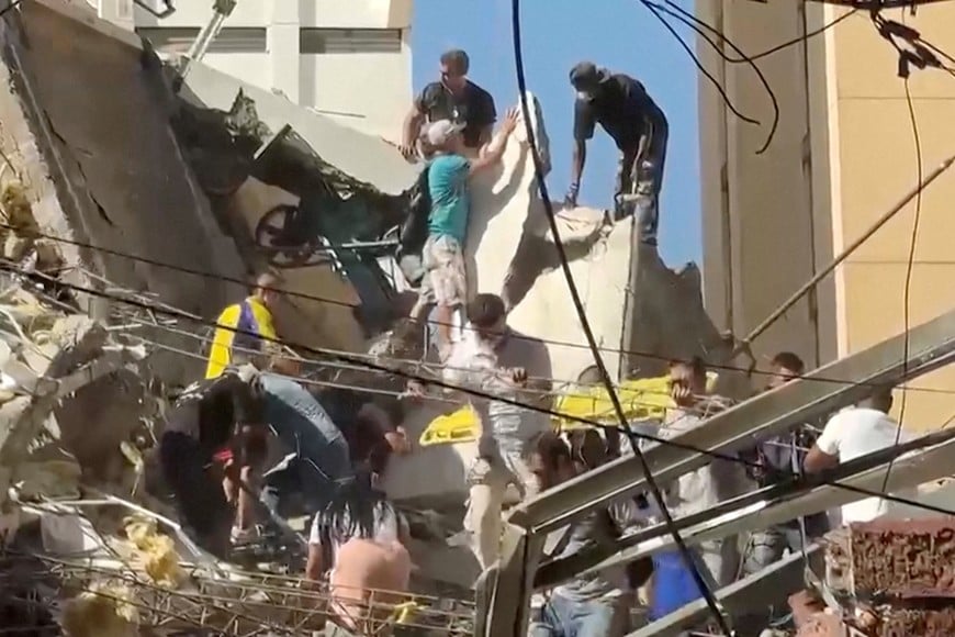 Rescue workers and residents stand atop a collapsed building in the aftermath of an earthquake in Cali, Colombia, August 10, 2026 in this screengrab taken from a video. REUTERS/Reuters TV