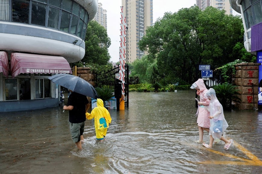 People walk through a flooded street after Typhoon Dolphin brought heavy rain to Shanghai, China, August 10, 2026. REUTERS/Go Nakamura