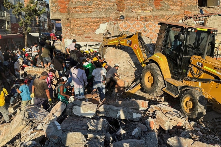 Residents and emergency personnel dig through the debris of a collapsed building following an earthquake, in Cali, Colombia August 10, 2026. Picture taken with a mobile phone. REUTERS/Marco Trujillo