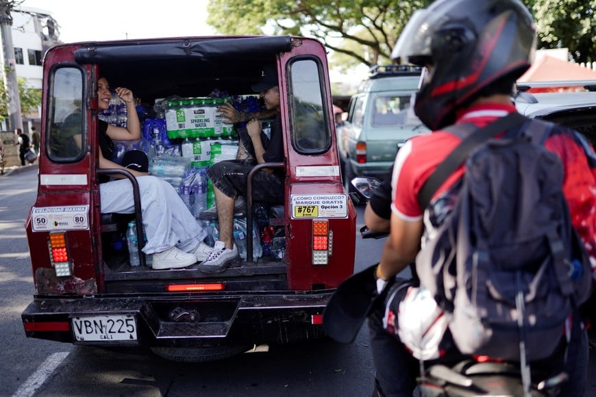 People sit in a vehicle transporting relief supplies in the aftermath of an earthquake, in Cali, Colombia, August 11, 2026. REUTERS/Sergio Acero
