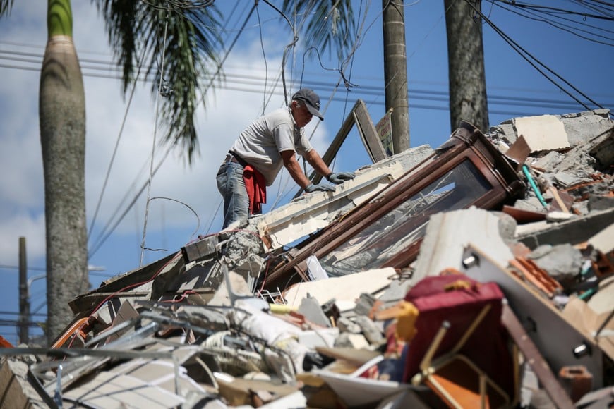 A resident digs through the debris of a collapsed building after an earthquake, in Dosquebradas, Colombia, August 10, 2026. REUTERS/Juan David Duque