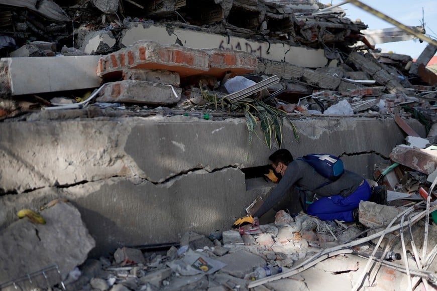 A man searches for survivors at the site of a collapsed building, in the aftermath of an earthquake, in Cali, Colombia, August 11, 2026. REUTERS/Sergio Acero