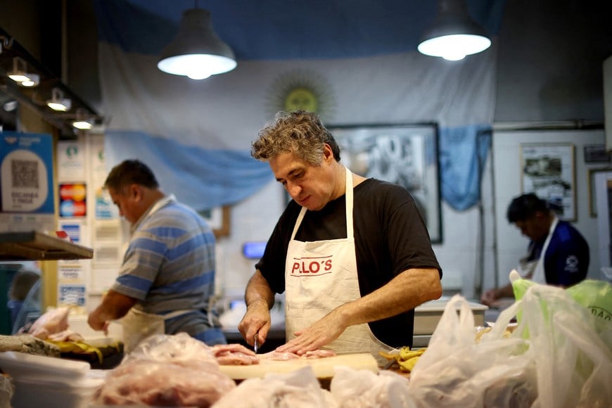 FILE PHOTO: A butcher chops chicken in a local market, in Buenos Aires, Argentina January 5, 2024. REUTERS/Agustin Marcarian/File Photo