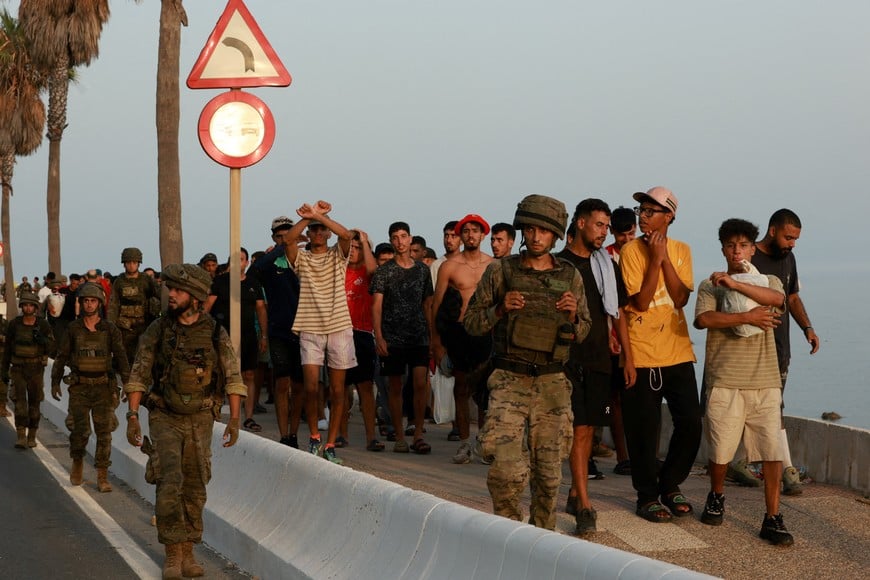 Members of the military escort migrants in Ceuta, Spain, following recent mass crossings of migrants on foot and by sea from Morocco into Spanish territory, August 1, 2026. REUTERS/Violeta Santos Moura TPX IMAGES OF THE DAY
