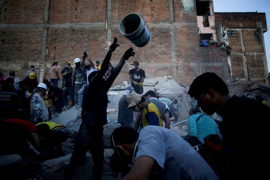 People work to clear debris at the site of a building damaged in an earthquake, in Pereira, Colombia, August 11, 2026. REUTERS/Juan David Duque