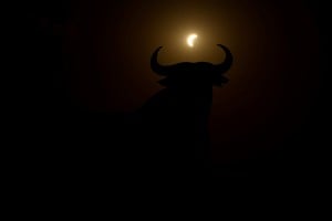 The moon partially covers the sun during a solar eclipse near the silhouette of an Osborne Bull, in Navarrete, northern Spain, August 12, 2026. REUTERS/Vincent West
