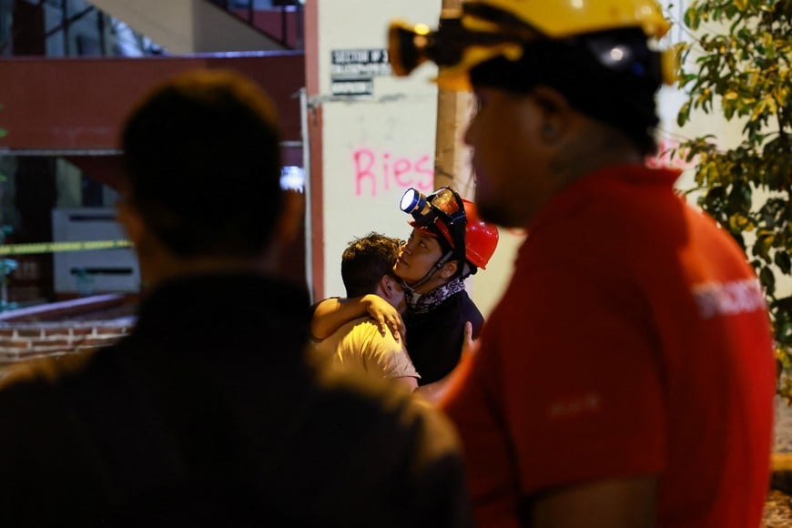 A man cries as he embraces a rescue worker in the aftermath of an earthquake, in Cali, Colombia, August 13, 2026. REUTERS/Raquel Cunha