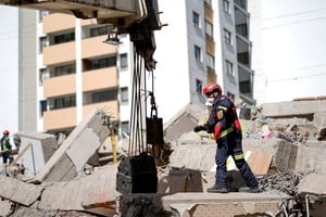 Equipos de rescate trabajan entre los escombros tras el fuerte movimiento.