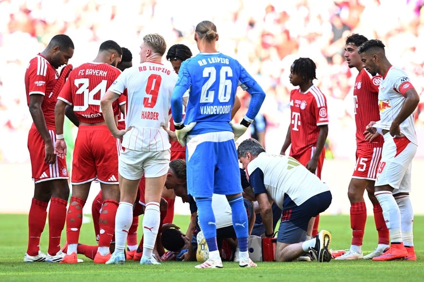 Soccer Football - Pre Season Friendly - Bayern Munich v RB Leipzig - Allianz Arena, Munich, Germany - August 15, 2026
Bayern Munich's Jamal Musiala receives medical attention after sustaining an injury as players look on REUTERS/Angelika Warmuth