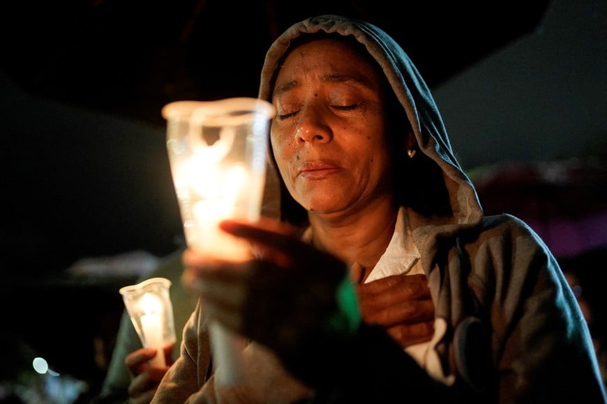 A woman reacts as she attends a candlelight vigil in memory of the victims of the August 10 earthquake, in Cali, Colombia, August 17, 2026. REUTERS/Sergio Acero TPX IMAGES OF THE DAY