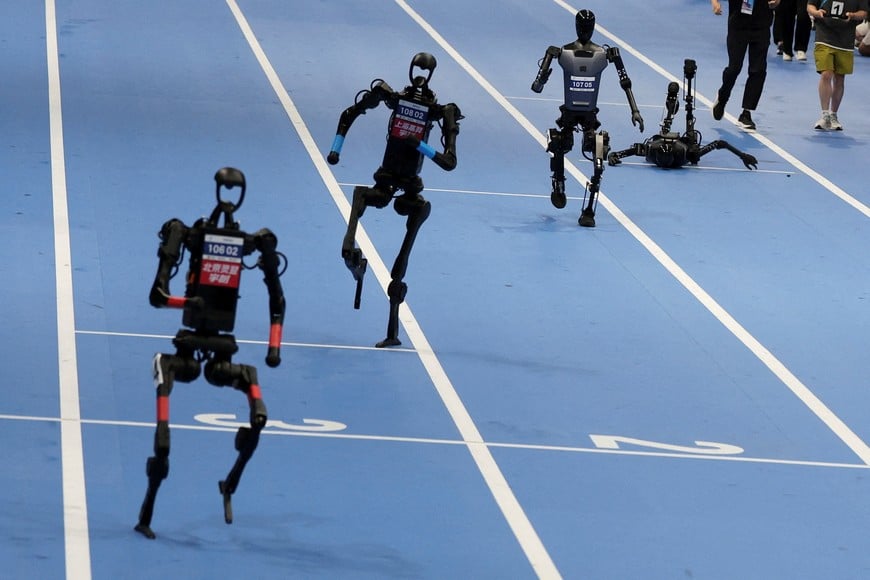 Unitree Robotics and Tiangong humanoid robots compete in the 100m final at the inaugural World Humanoid Robot Games, at the National Speed Skating Oval in Beijing, China August 17, 2025. REUTERS/Florence Lo TPX IMAGES OF THE DAY