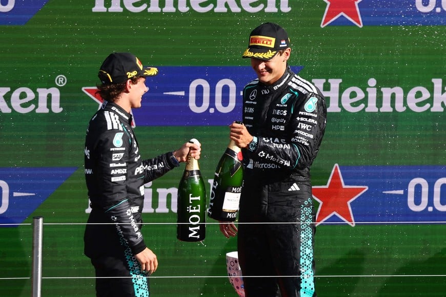 Formula One F1 - Dutch Grand Prix - Circuit Zandvoort, Zandvoort, Netherlands - August 23, 2026
Second placed Mercedes' Andrea Kimi Antonelli celebrates on the podium with third placed Mercedes' George Russell after the Dutch Grand Prix REUTERS/Jakub Porzycki