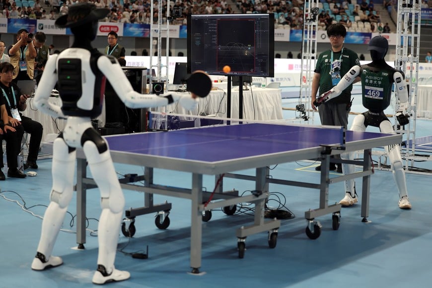 Humanoid robots take part in a table tennis competition, during the second World Humanoid Robot Games at the National Speed Skating Oval in Beijing, China August 23, 2026. REUTERS/Florence Lo