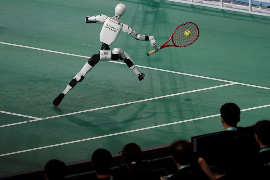 A Galbot humanoid robot takes part in a tennis exhibition match against a human player during the opening ceremony for the second World Humanoid Robot Games at the National Speed Skating Oval in Beijing, China August 22, 2026. REUTERS/Florence Lo 
     TPX IMAGES OF THE DAY