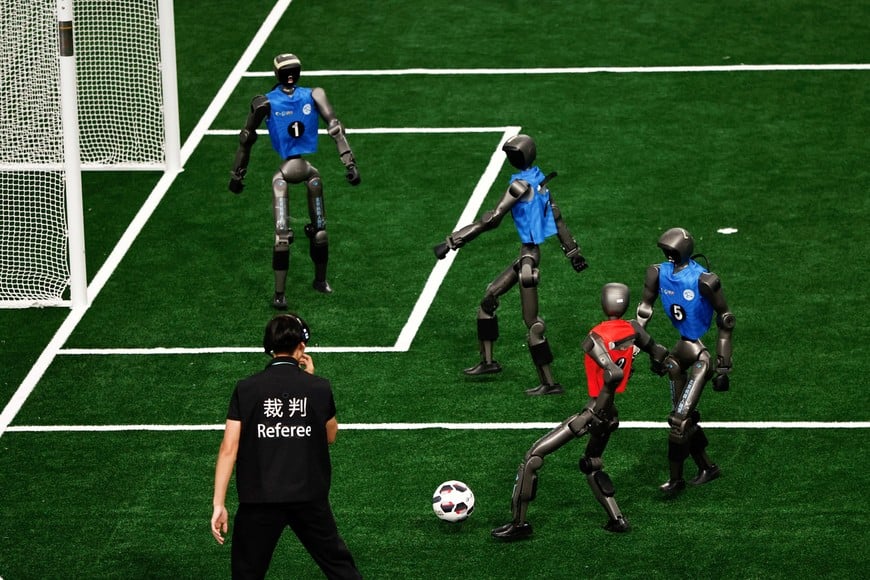 T2 humanoid robots by Booster Robotics take part in a quarterfinal of 5v5 large size group football match, during 2026 World Humanoid Robot Games, at the National Speed Skating Oval, in Beijing, China August 23, 2026. REUTERS/Tingshu Wang