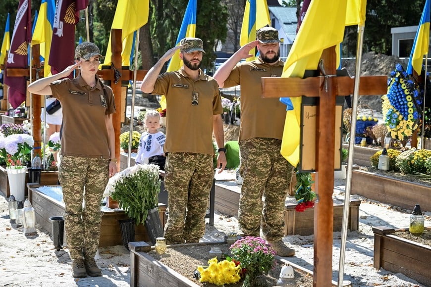 Service members visit a graveyard with tombs of Ukrainian servicemen who were killed in a fight against Russian troops, amid Russia's attack on Ukraine, during Independence Day in Lviv, Ukraine August 24, 2026. REUTERS/Stringer