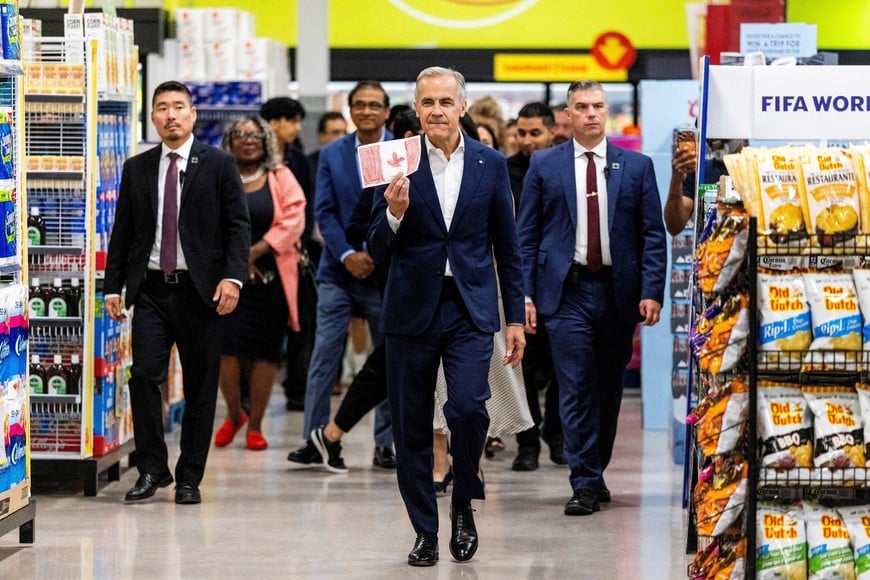 Canadian Prime Minister Mark Carney shows a card given to him by Jagandeep Sodhi during a visit to Chalo FreshCo grocery store in Brampton, Ontario, Canada, June 5, 2026. REUTERS/Carlos Osorio     TPX IMAGES OF THE DAY