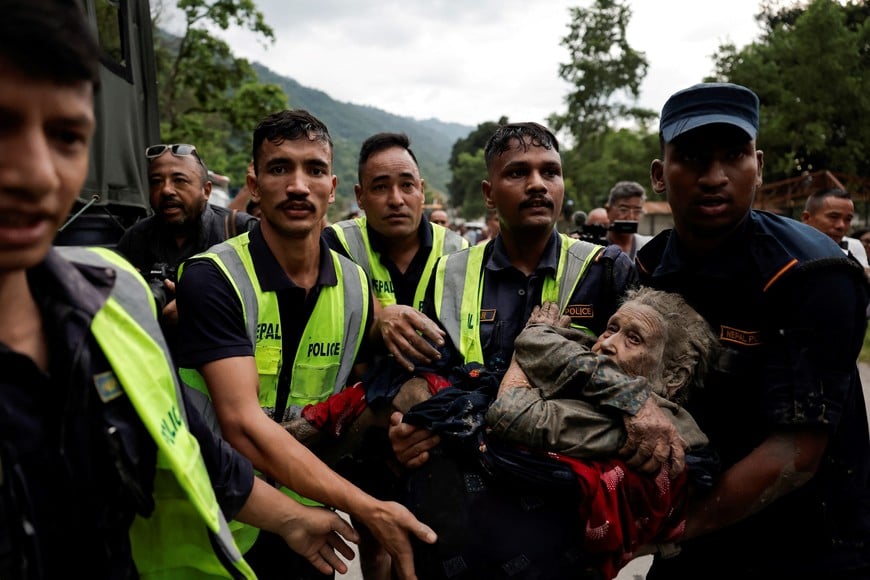 Police officers carry a survivor to a safer place following a flash flood at Trishuli in Nuwakot district, Nepal, August 26, 2026. REUTERS/Navesh Chitrakar REFILE - QUALITY REPEAT    TPX IMAGES OF THE DAY