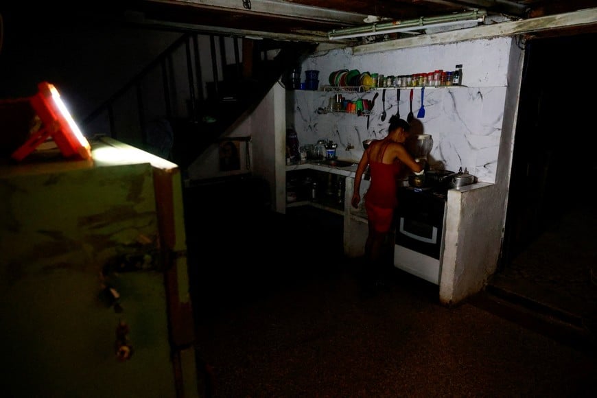 Regla Caridad Gomez, a 46-year-old homemaker, prepares food at home as Cuba's national electrical grid collapsed according to the country's grid operator, UNE, marking the second total outage in a week and the fourth this year, in Havana, Cuba, July 10, 2026. REUTERS/Norlys Perez TPX IMAGES OF THE DAY