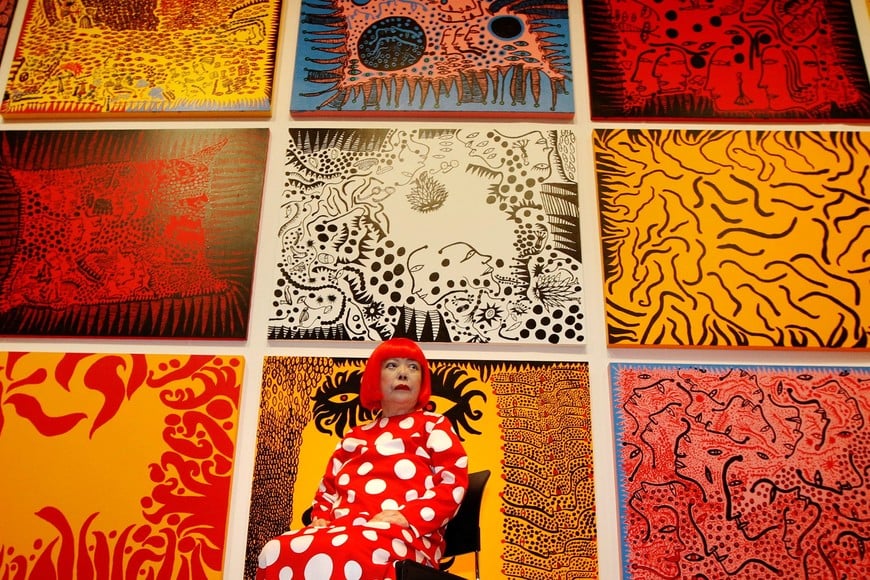 FILE PHOTO: Artist Yayoi Kusama poses for a photograph with her artwork "Love arrives at the Earth Carrying with it a Tale of the Cosmos" at the Tate Modern gallery in London, Britain, February 7, 2012. REUTERS/Luke MacGregor/File Photo