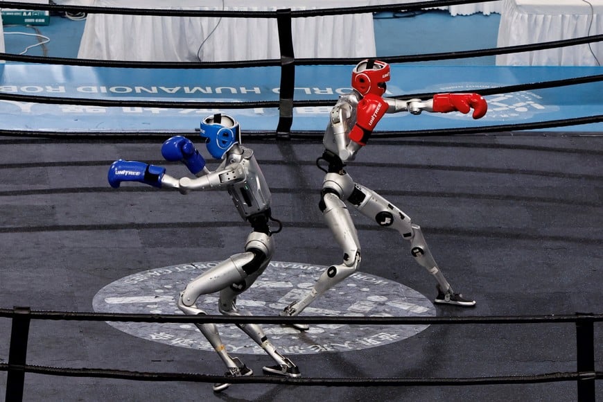 Humanoid robots by Unitree Robotics compete during a kickboxing 80kg third-place match at the 2026 World Humanoid Robot Games at the National Speed Skating Oval in Beijing, China August 26, 2026. REUTERS/Tingshu Wang