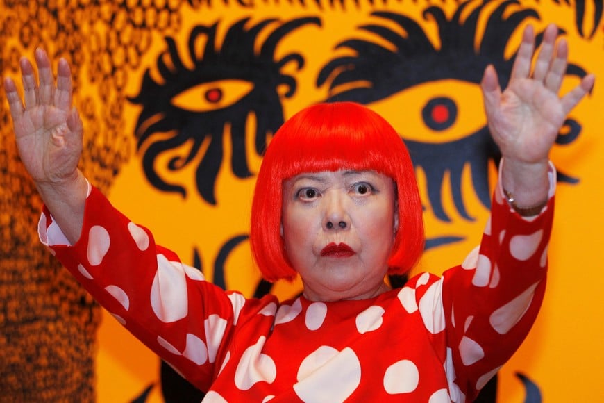 FILE PHOTO: Artist Yayoi Kusama poses for a photograph with a detail from her artwork "Love arrives at the Earth Carrying with it a Tale of the Cosmos" at the Tate Modern gallery in London, Britain, February 7, 2012. REUTERS/Luke MacGregor/File Photo