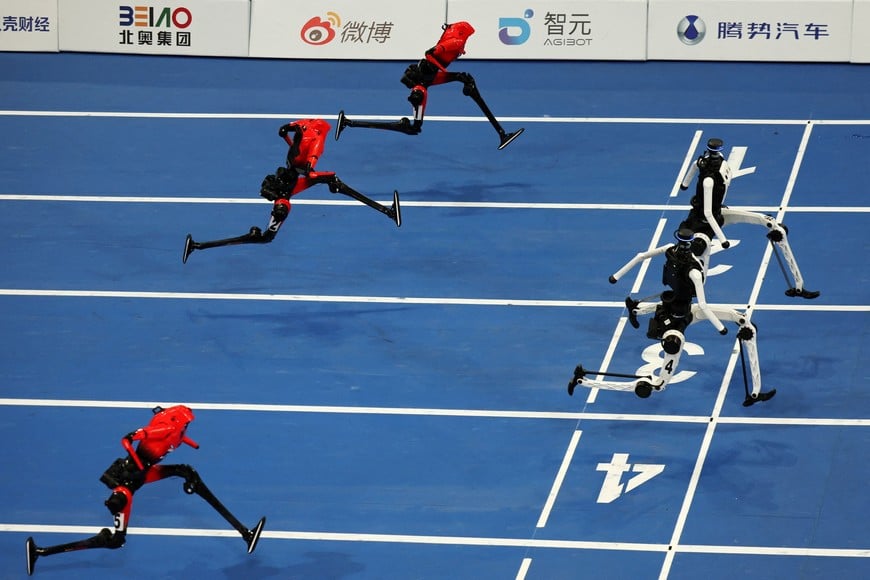 Tiangong Ultra humanoid robots cross the finish line before Honor's Lightning humanoid robots in the 100m large-size group final race, during the second World Humanoid Robot Games at the National Speed Skating Oval in Beijing, China August 26, 2026. REUTERS/Florence Lo